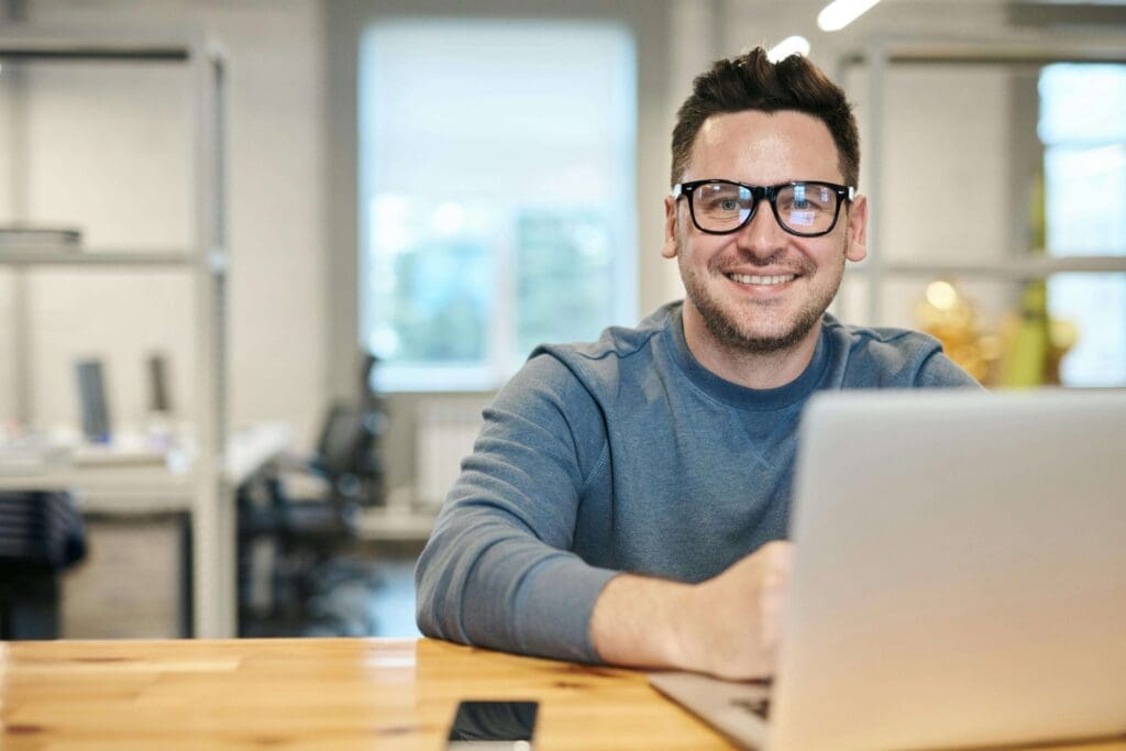 A man, smiling, is following a Programmatic Course to get certified.